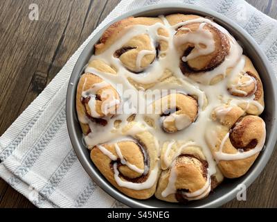 Panini alla cannella appena sfornati in una teglia rotonda Foto Stock