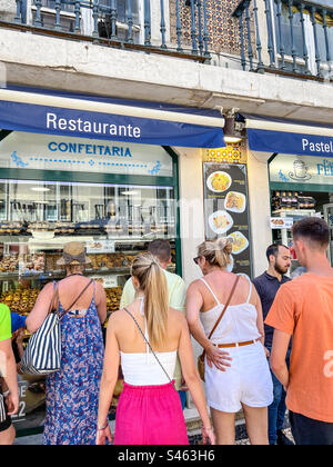 I turisti che guardano la preparazione delle crostate pasticciere Pastéis de nata a Lisbona in Portogallo Foto Stock