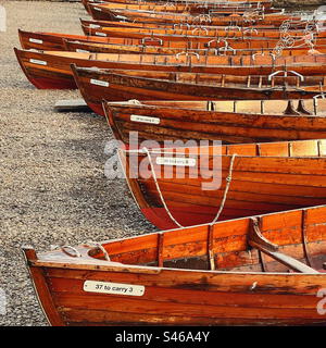 Barche a remi spiaggiavano sulla riva a Keswick nel Lake District Foto Stock