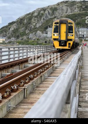 Treno in avvicinamento lungo una ferrovia che attraversa un estuario Foto Stock