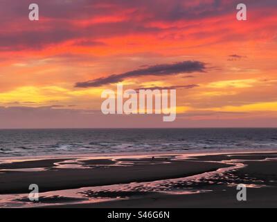 Cane per due persone al tramonto sulla spiaggia nord di Blackpool Foto Stock