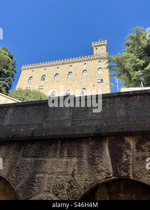 Piazza pubblico della Repubblica di San Marino, edificio che si affaccia su un cielo limpido e azzurro, domina la vista dalla via inferiore del Giardino dei Liburni Foto Stock