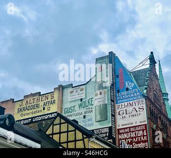Pubblicità in vecchio stile dipinte sulle pareti di vecchi edifici a Malmö, Svezia. Foto Stock