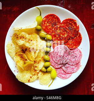 Patate fritte con peperoncino rosso caldo, olive, peperoncino piccante giallo cascabella, salame e chorizo spagnolo per tapas a Queretaro, Messico Foto Stock