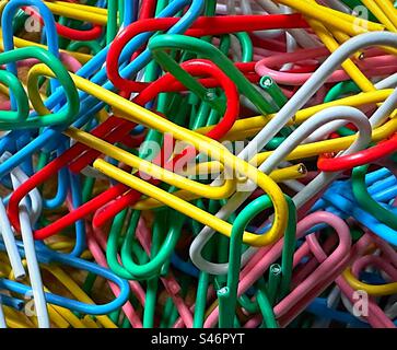 «Paper Clip Puzzle»: Primo piano di un ampio fascio di graffette multicolore in una pila. Foto Stock