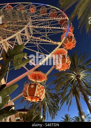 Illuminazione notturna di palme e "Giant Wheel" Ferris presso l'Irvine Spectrum Center, un complesso per lo shopping e l'intrattenimento nella contea di Orange, California. Foto Stock