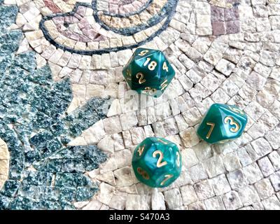 Dadi da gioco di ruolo - 3 dadi verdi incluso d20 su un tavolo a mosaico Foto Stock