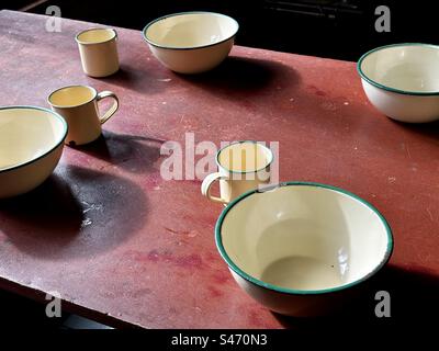 Smalto tazze e ciotole sul tavolo Foto Stock