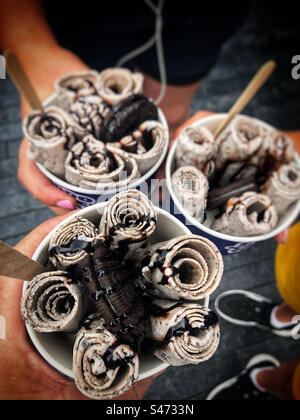 I bambini in vacanza a Londra durante un'ondata di caldo nel mese di agosto gustando il gelato arrotolato sulla South Bank Foto Stock