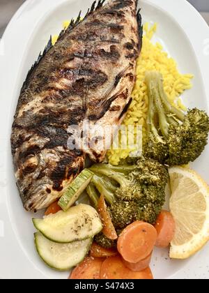 Una sana cena mediterranea a base di pesce, riso e verdure. Foto Stock