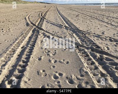 Tracce di pneumatici nella sabbia sulla spiaggia Foto Stock