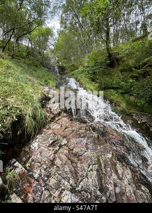 A pochi passi da Steall Falls. Lungo il percorso per la cascata di Steall, la gola di Nevis, vicino a Ben Nevis e Fort William in Scozia. Paesaggi e piccole cascate lungo il percorso verso la cascata principale. Foto Stock
