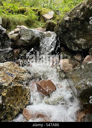 A pochi passi da Steall Falls. Lungo il percorso per la cascata di Steall, la gola di Nevis, vicino a Ben Nevis e Fort William in Scozia. Paesaggi e piccole cascate lungo il percorso verso la cascata principale. Foto Stock