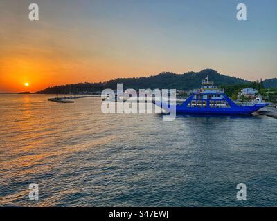Alba con traghetto blu nel porto di Limenas sull'isola di Thassos in Grecia. Foto Stock