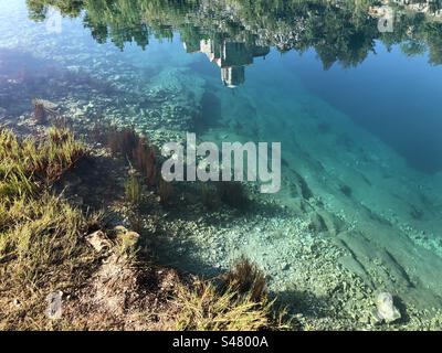 Sorgente del fiume Cetina, entroterra dalmata della Croazia, chiesa ortodossa - riflesso in acqua Foto Stock