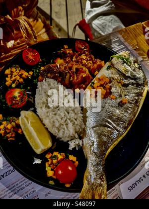 Ristorante con specialità di pesce, orata di mare, cena, pranzo, cena, riso, pomodori, limone, verdure arrostite a sud della Francia, 10-7-23 Foto Stock