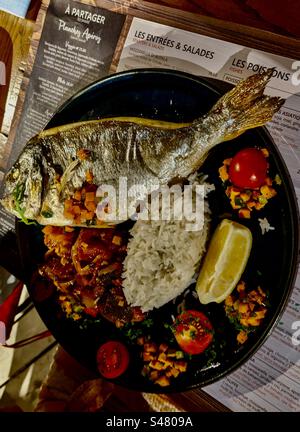 Ristorante con specialità di pesce, orata di mare, cena, pranzo, cena, riso, pomodori, limone, verdure arrostite a sud della Francia, 10-7-23 Foto Stock