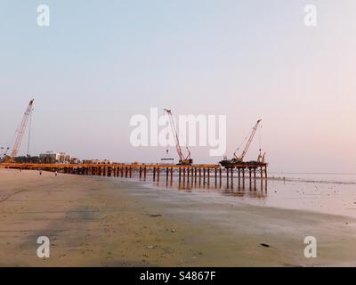 Costruzione della strada costiera sulla spiaggia di Versova a Mumbai, India al tramonto Foto Stock