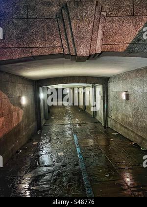 Sotto il Westminster Bridge a Londra - il tunnel passa sotto la strada - visto di notte sotto la pioggia con riflessi e rifiuti Foto Stock