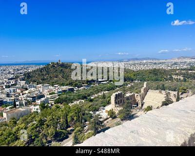 La città di Atene, vista dal colle dell'Acropoli, si affaccia sull'Odeione all'aperto dell'anfiteatro di Erode Attico, ancora oggi utilizzato come luogo di intrattenimento Foto Stock