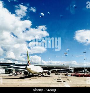 La pioggia cade sul finestrino dell'aereo all'aeroporto Foto Stock