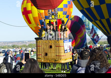 Emozionate le persone in mongolfiera mentre decollano da terra al balloon fiesta di Albuquerque, New Mexico Foto Stock