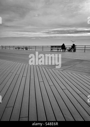 Persone sedute su una passerella Foto Stock