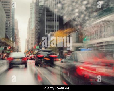 Sentieri leggeri e traffico offuscato sotto la pioggia, New York City Foto Stock