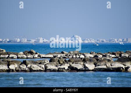 Ampio paesaggio teleobiettivo di la grande Motte e Port Camargue visto dal molo di Palavas-les-Flots, Occitanie, Francia Foto Stock