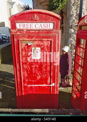 Vecchia cabina telefonica britannica trasformata in distributore di contanti sulla strada principale di Conwy, Galles del Nord. Foto Stock