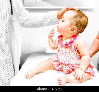 Medico pediatrico che controlla la fontanelle anteriore del bambino Foto Stock