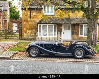 Broadway, Cotswolds, Inghilterra, Regno Unito - novembre 2923: Auto sportiva Morgan classica parcheggiata all'esterno di un cottage nel grazioso villaggio Cotswolds di Broadway Foto Stock