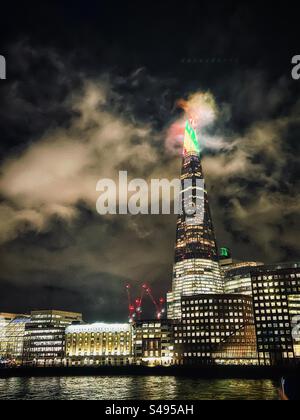 Luci rosse, gialle e verdi sullo Shard, si dice che sia la torre più alta di Londra sulle rive del Tamigi vista in una notte nuvolosa Foto Stock