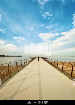 Vista posteriore di un uomo che cammina sul molo verso la piattaforma panoramica di Shakespeare Grove nel mare di St Kilda, Victoria, Australia. Solitudine. La strada da seguire. Prospettiva in diminuzione. Scenics-natura. Foto Stock