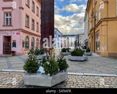 Decorazioni natalizie con piccoli pini su una grande strada pedonale nel centro storico di Cheb, Repubblica Ceca. Foto Stock