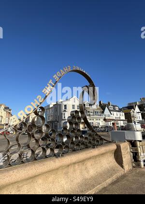 ‘Waves Shape the Shore' on the sea wall at Seaton in Devon Foto Stock