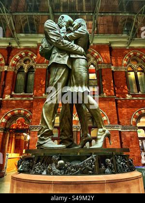 "La statua degli amanti" o "la statua del luogo d'incontro" dello scultore Paul Day presso la stazione ferroviaria di Londra St Pancras con la sua architettura gotica vittoriana sullo sfondo Foto Stock