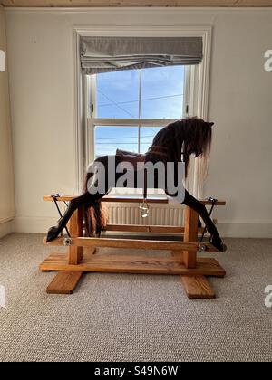 Rocking Horse in una stanza accanto a una finestra in una casa Foto Stock