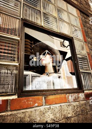 Manichino in vetrina con solo testa. Modella donna che indossa occhiali da sole, parrucca e cappello da cowboy. Si trova nel centro di Boulder, Colorado, Stati Uniti. Foto Stock