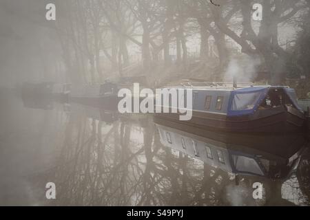 Barche strette ormeggiate in una mattinata nebbiosa sul canale di Leeds e Liverpool ad Adlington nel Lancashire Foto Stock