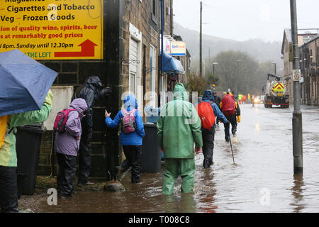 Walsden,Todmorden, Calderdale, UK. 16 marzo 2019. Pioggia pesante è causa di strade di alluvione nella valle di Calder. Le persone sono a piedi attraverso l'acqua di inondazione per rendere il loro modo per le loro destinazioni .Walsden,Todmorden, Calderdale, Regno Unito, 16 marzo 2019 (C)Barbara Cook/Alamy Live News Credito: Barbara Cook/Alamy Live News Foto Stock