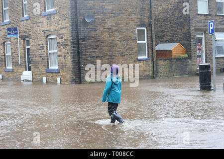 Walsden,Todmorden, Calderdale, UK. 16 marzo 2019. Un giovane camminare in mezzo alla strada che è stata chiusa a causa di inondazioni, Walsden,Todmorden, Calderdale, Regno Unito, 16 marzo 2019 (C)Barbara Cook/Alamy Live News Credito: Barbara Cook/Alamy Live News Foto Stock