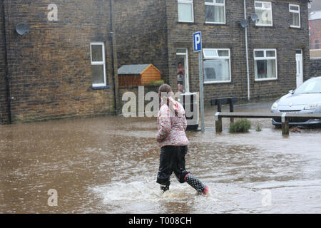 Walsden,Todmorden, Calderdale, UK. 16 marzo 2019. Un giovane camminare in mezzo alla strada che è stata chiusa a causa di inondazioni, Walsden, Todmorden, Calderdale, Regno Unito, 16 marzo 2019 (C)Barbara Cook/Alamy Live News Credito: Barbara Cook/Alamy Live News Foto Stock