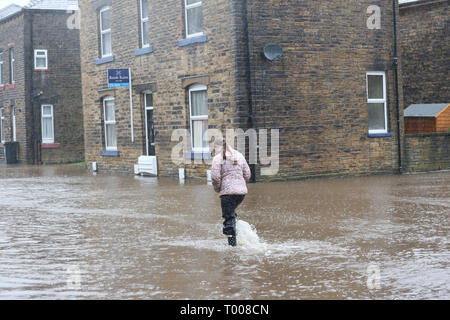 Walsden,Todmorden, Calderdale, UK. 16 marzo 2019. Un giovane camminare in mezzo alla strada che è stata chiusa a causa di inondazioni, Walsden, Todmorden, Calderdale, Regno Unito, 16 marzo 2019 (C)Barbara Cook/Alamy Live News Credito: Barbara Cook/Alamy Live News Foto Stock