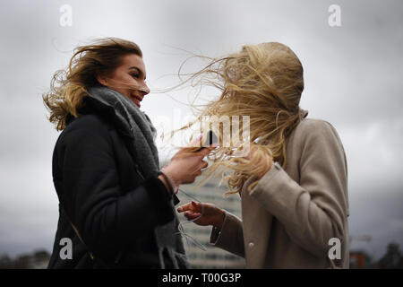 Turisti durante i forti venti su Westminister Bridge di Londra. Foto Stock