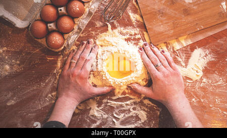 Femmina professionale baker la cottura di pasta con le uova e la farina per la cottura di Pasqua Foto Stock