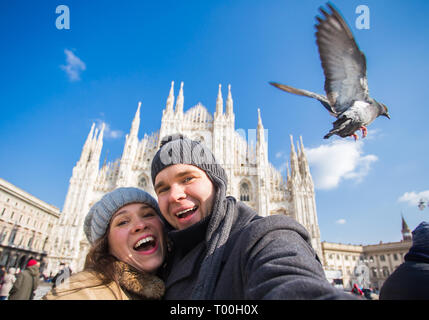 Viaggi, Italia e divertente giovane concetto - Happy turisti prendendo un autoritratto con piccioni nella parte anteriore del Duomo di Milano Foto Stock