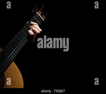 Mano a giocare della chitarra spagnola su sfondo nero Foto Stock