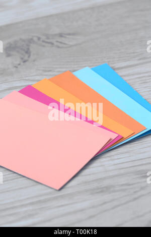 Vernice di colore swatch carte su di un legno grigio sfondo con colori rosa arance e blues Foto Stock