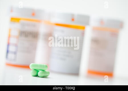Le capsule di verde di fronte arancione bottiglie in farmacia Foto Stock